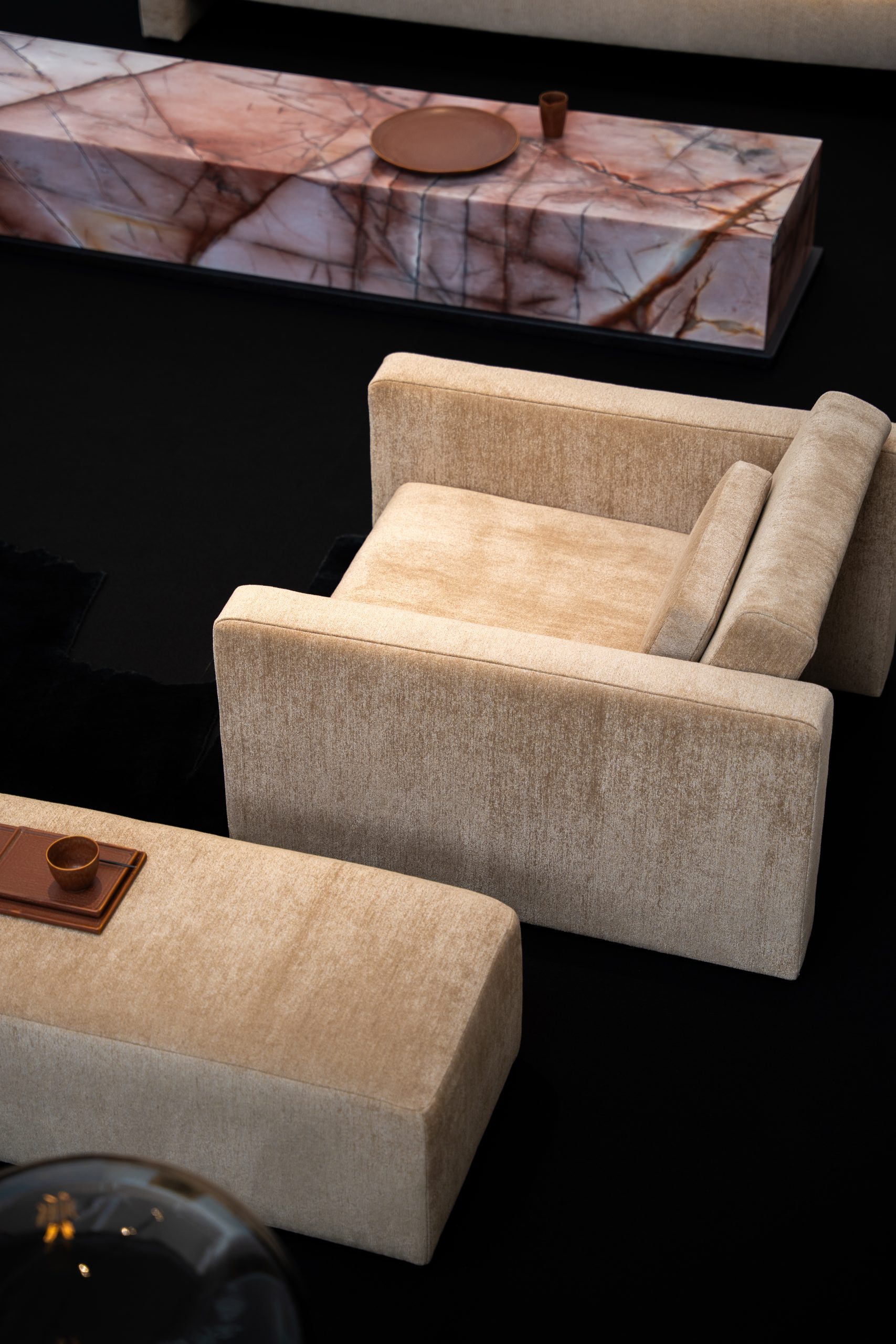 Fauteuil et repose-pieds en tissu, table en pierre naturelle